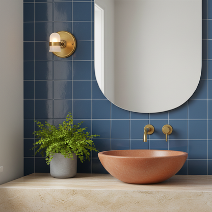 Halo antique brass wall light with frosted glass beside a colorful bathroom mirror