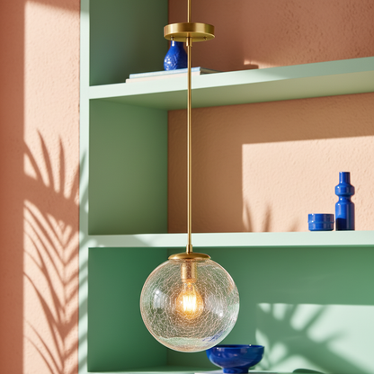Close-up of the Aurelia crackled glass globe and polished brass pendant details in a colorful interior